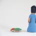 Kneeling Muñeca in Blue Dress with Carrots and Plate of Carrots