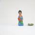 Kneeling Muñeca in Blue Dress with Carrots and Plate of Carrots